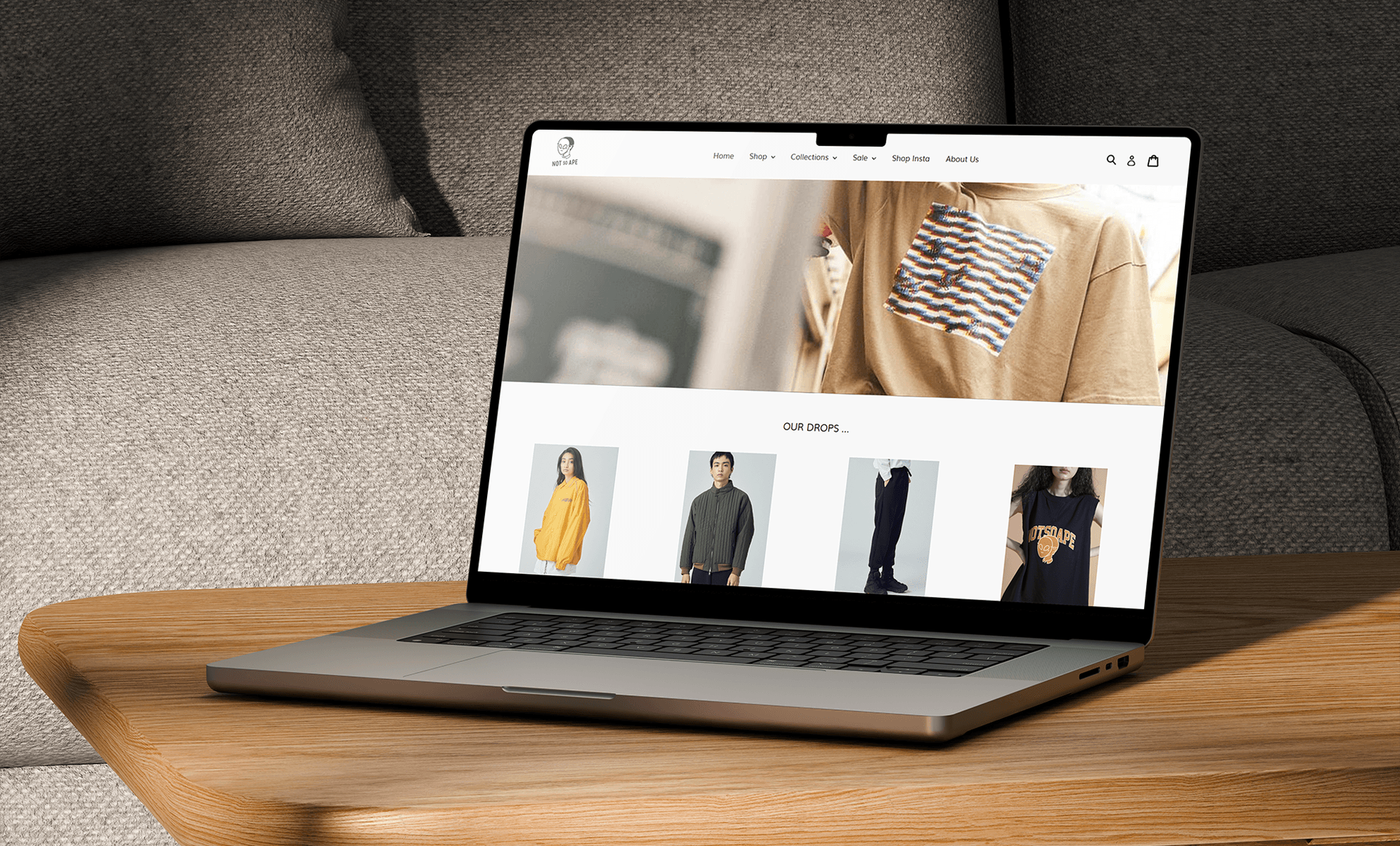 Laptop on gray sofa showing an e-commerce fashion website