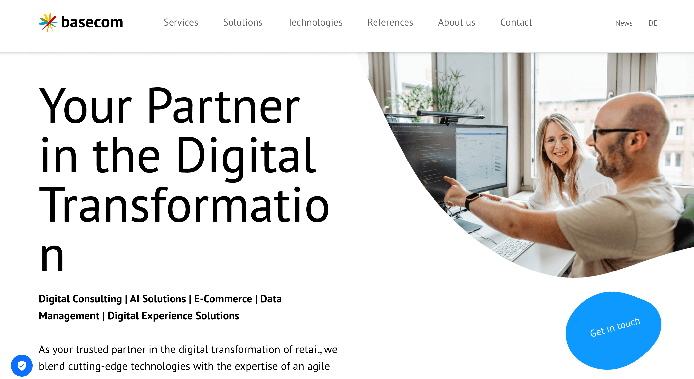 Two colleagues collaborate at a computer in a bright office beside text about digital transformation services.