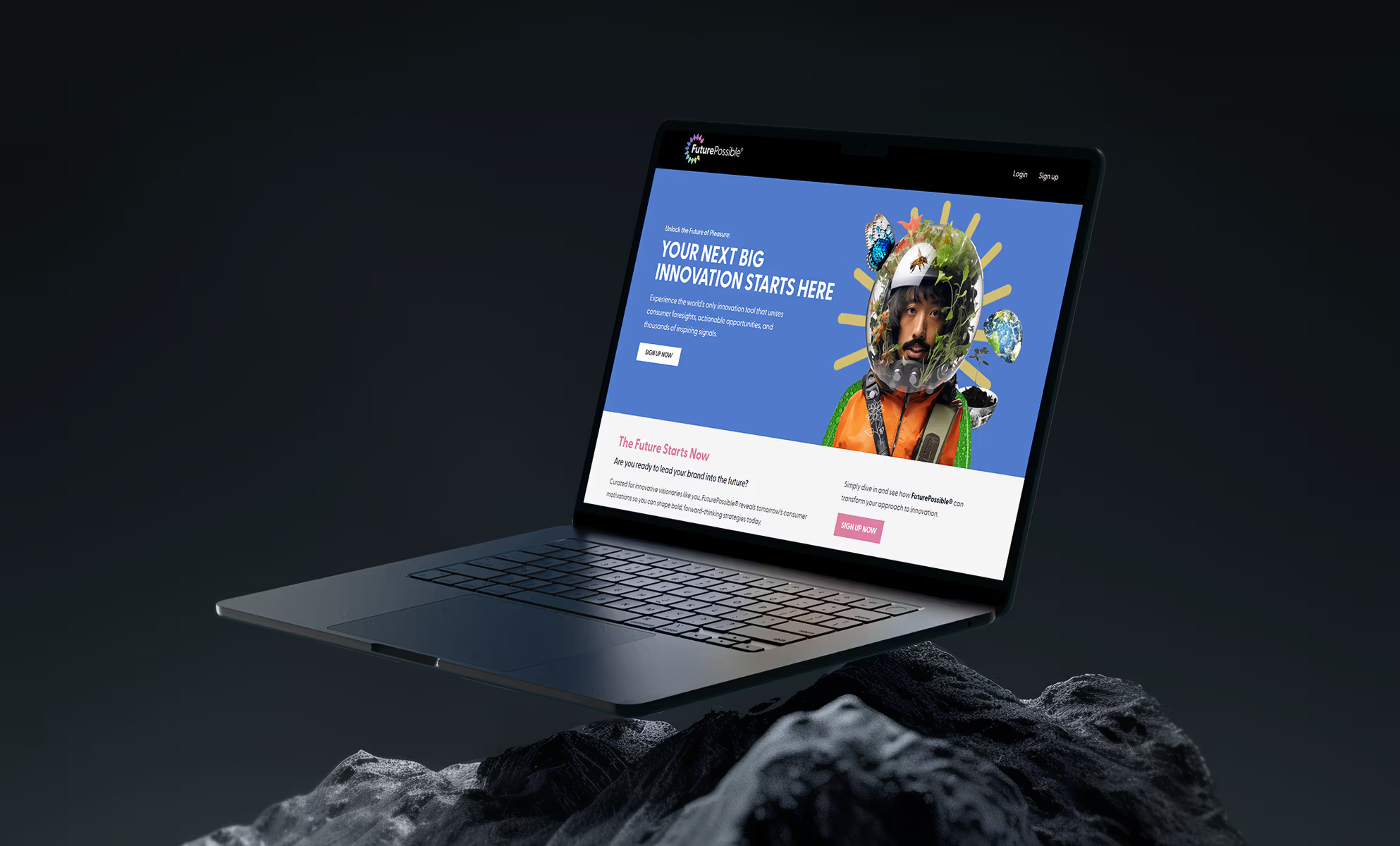 Laptop displaying website with colorful artistic portrait on dark rocky surface