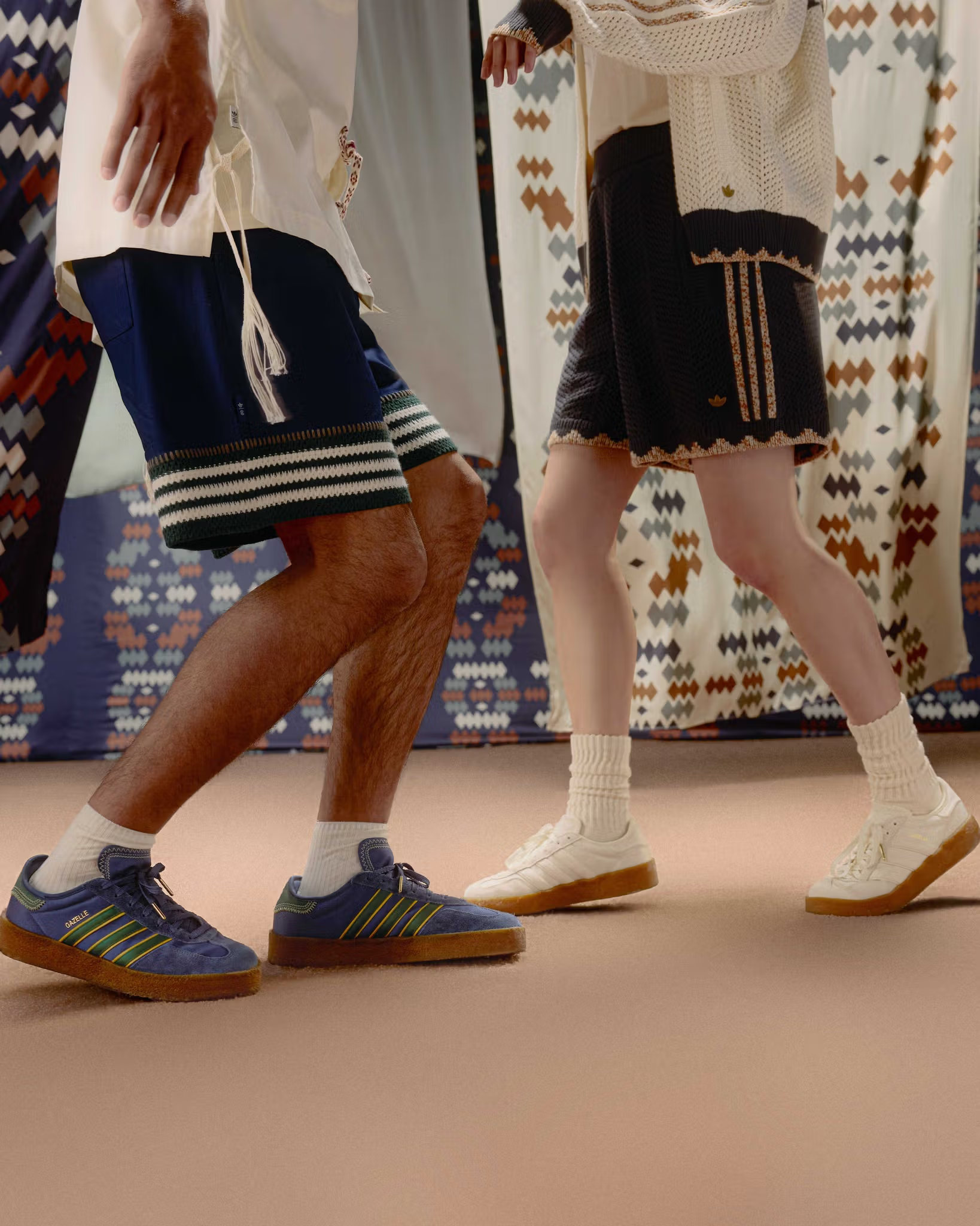 Two people walking past retail display with sneakers on blue carpet