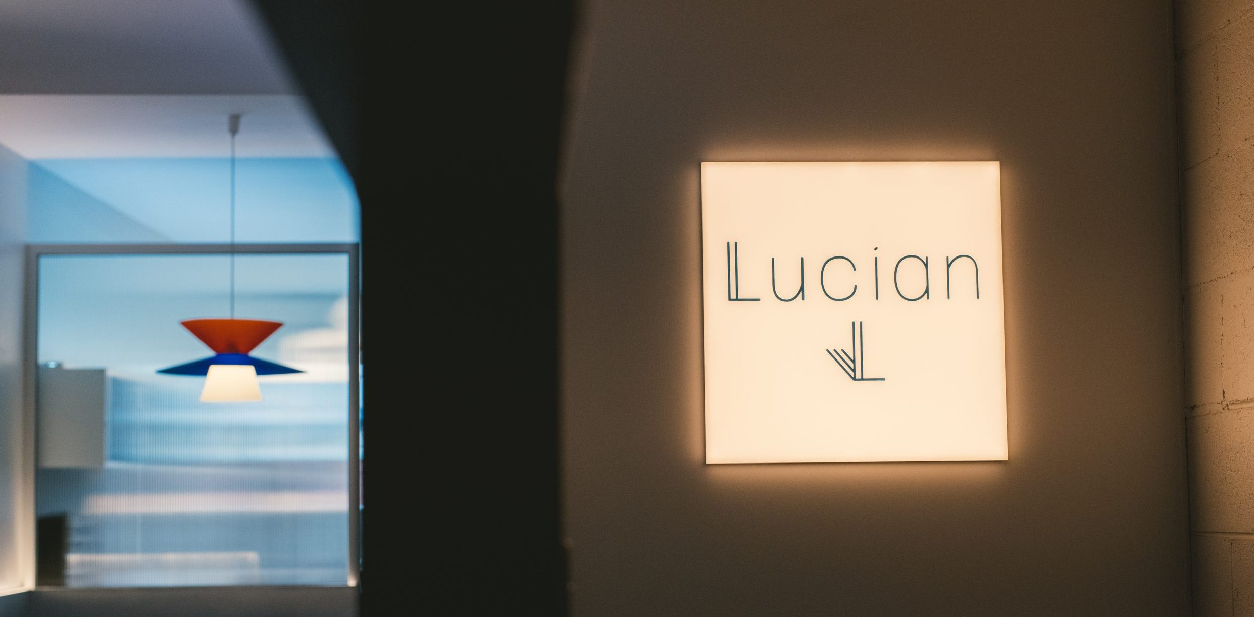 Lucian sign with arrow on illuminated wall in hotel interior