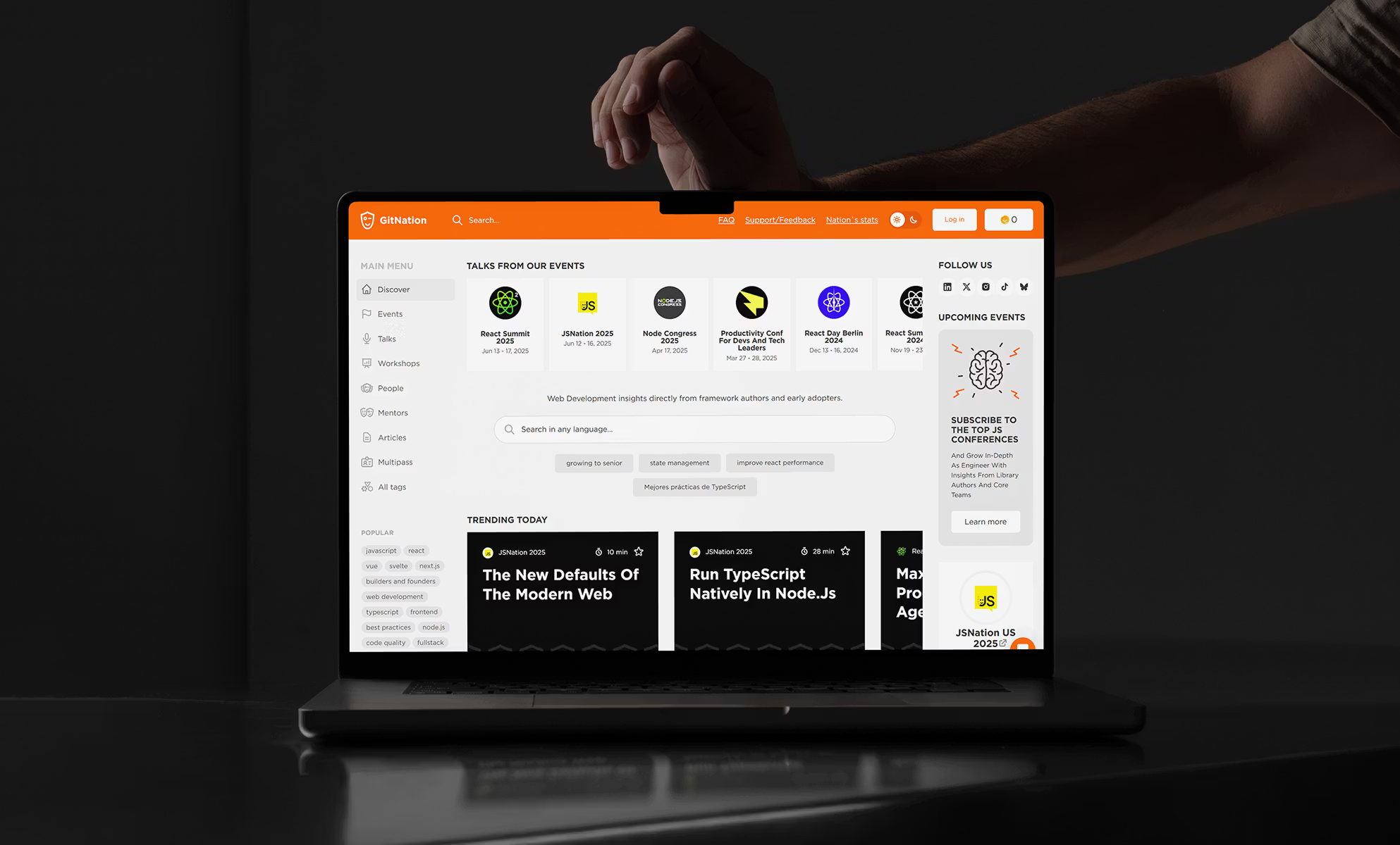 Laptop displaying Product Hunt-style website on dark background with orange accents